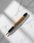 Pen with wooden finish and black accents on a marble surface